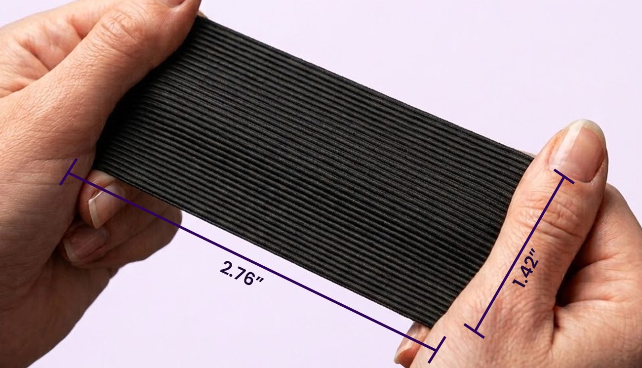 Hands stretching a black Steelhaus strip measuring 2.76 by 1.42 inches